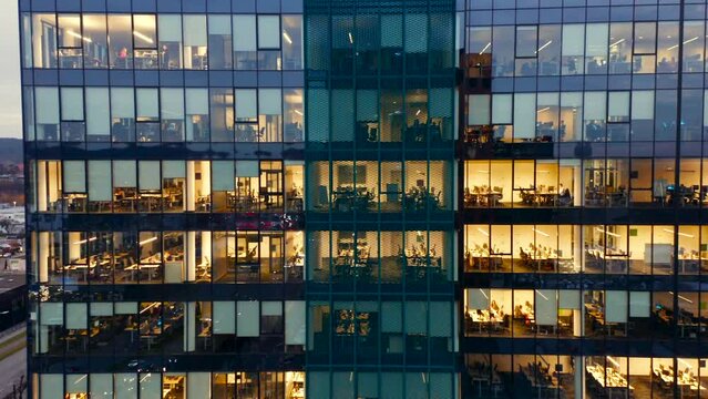 Aerial View of the Windows of a Skyscraper Where People Work in an Office Building in the Financial Center of the City at Night. Gdansk, Poland. Facade of night skyscraper windows Corporate offices
