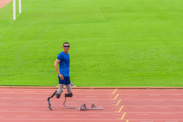 Asian athlete with prosthetics, poised at start block, primed for high-speed run on stadium track