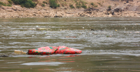 Garbage, plastic and a matress floating downstream on the Mekong river between Huay Xay and Pak Beng, Laos.