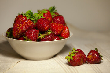 Bowl of sweet appetizing strawberries on a napkin.