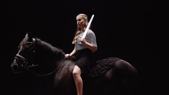 Female Knight Riding Horse In Studio