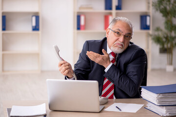 Old male employee working in the office