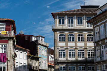 Fototapeta na wymiar Guimaraes, Portugal. April 14, 2022: Architecture and facade of the city Guimaraes with blue sky.