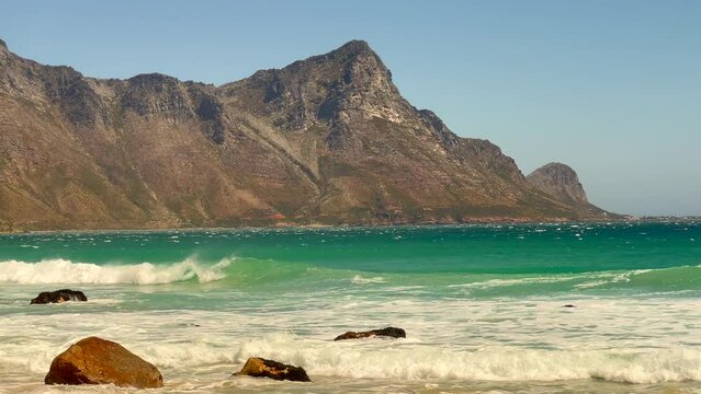 Koeel Bay Dappat Se Gat cinematic windy polarized surf waves crashing stunning Kogel Bay Beach Cape Town South Africa coastline aqua deep blue water Gordon's Bay  Garden Route forward pan left
