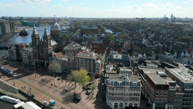 Aerial view of the Amsterdam city center. Iconic local buildings. Beauty of the city on the sunny day. High quality 4k footage shot by a drone. 
