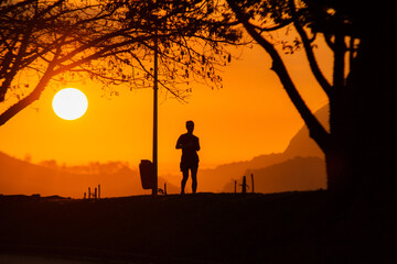 Fototapeta premium silhouettes of people running during dawn in Rio de Janeiro.