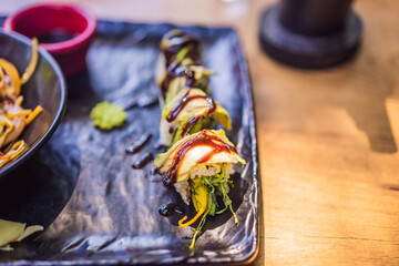 Asian noodles and sushi in black bowl