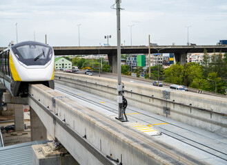 Elevated monorail train on rail. Public transit monorail. Modern mass transit. Rail transportation. Driverless straddle monorail on concrete guideway beam with conductor rail. Monorail technology.