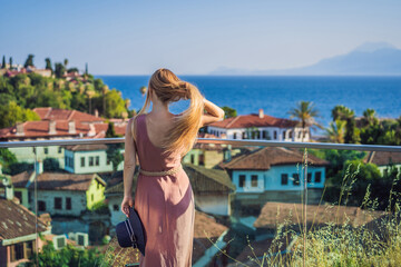 Obraz premium Woman tourist in Old town Kaleici in Antalya. Turkiye. Panoramic view of Antalya Old Town port, Taurus mountains and Mediterrranean Sea, Turkey