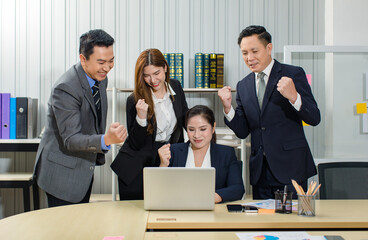 Asian professional successful male female businessmen businesswomen in formal business suit sitting standing smiling holding fists up celebrating customer goal deal done victory winning achievement