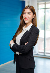 Portrait shot of Asian professional successful smart confident female businesswoman ceo entrepreneur in formal business suit pants standing crossed arms smiling look at camera in company office room