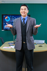 Portrait shot of Millennial Asian professional successful male businessman ceo entrepreneur in formal business suit standing  posing smiling look at camera in meeting office room