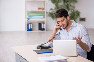 Fototapeta premium Young male employee working in the office