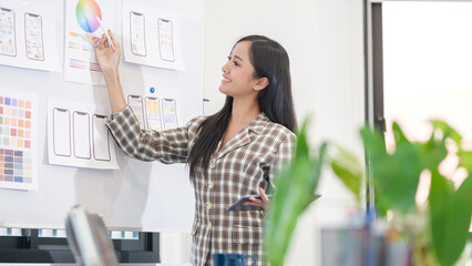 Creative woman web designer looking at whiteboard, working  on web and ui application development usability .