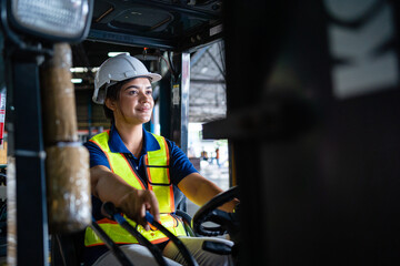 Female factory worker is driving a forklift in a large warehouse. A caring female factory worker drives a forklift in the factory. Transportation, transportation, logistics.