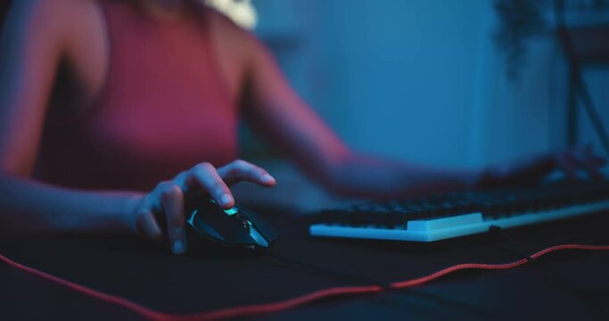 Footage of Young Asian esport woman gamers playing online video games on the computer with neon light at home. Attractive girl gaming player feels enjoy technology broadcast live streaming.