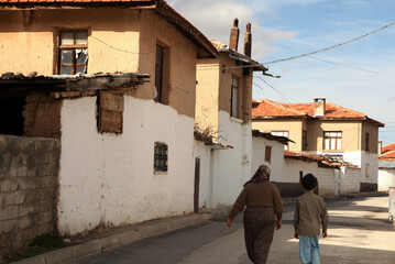 Grandmother and granddaughter walking in an old street. Konya Turkey