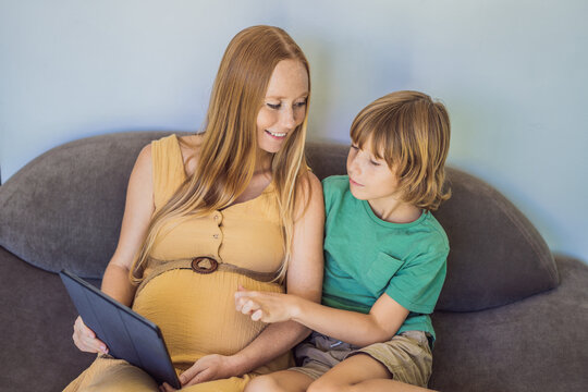 pregnant mom and son look at the tablet. Reading a book or watching a cartoon or making a video call. Look at the photo from the ultrasound