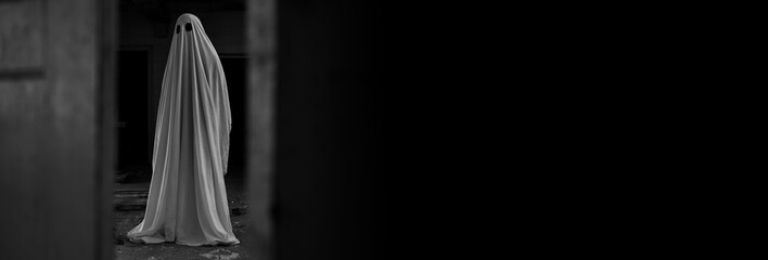 Ghost covered with a white ghost sheet in abandoned house. Image vintage look.