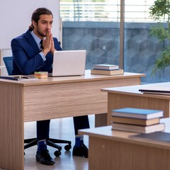 Young male teacher in suit in the classroom