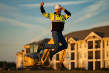 Jump excited worker. Builder man at building site. Construction manager in helmet. Male construction engineer. Architect at a construction site. Handyman builder in hardhat.