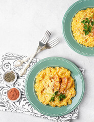 Risotto with pumpkin on the green plate on the table. top vertical view, copy space