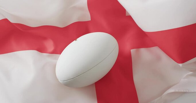 White rugby ball over waving flag of england with copy space, in slow motion