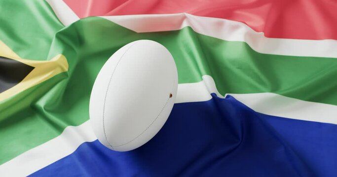 White rugby ball over flag of south africa with copy space, in slow motion