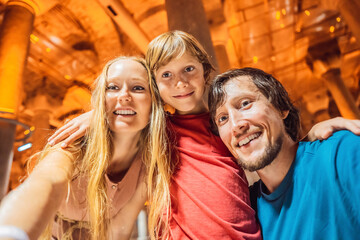 Father, mother and son tourists enjoying Beautiful cistern in Istanbul. Cistern - underground water reservoir build in 6th century, Istanbul, Turkey, Turkiye