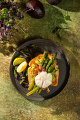 Grilled Toast witch Asparagus, avocado, Poached egg, greens, bacon on green textured background. banner, menu recipe place for text, top view. Traditional breakfast.