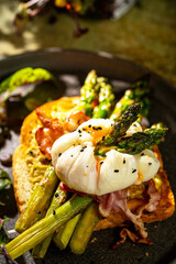 Grilled Toast witch Asparagus, avocado, Poached egg, greens, bacon on green textured background. banner, menu recipe place for text, top view. Traditional breakfast.