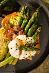 Grilled Toast witch Asparagus, avocado, Poached egg, greens, bacon on green textured background. banner, menu recipe place for text, top view. Traditional breakfast.