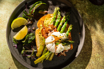 Grilled Toast witch Asparagus, avocado, Poached egg, greens, bacon on green textured background. banner, menu recipe place for text, top view. Traditional breakfast.