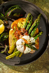 Grilled Toast witch Asparagus, avocado, Poached egg, greens, bacon on green textured background. banner, menu recipe place for text, top view. Traditional breakfast.