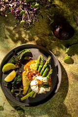 Grilled Toast witch Asparagus, avocado, Poached egg, greens, bacon on green textured background. banner, menu recipe place for text, top view. Traditional breakfast.