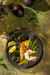 Grilled Toast witch Asparagus, avocado, Poached egg, greens, bacon on green textured background. banner, menu recipe place for text, top view. Traditional breakfast.