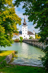 Fototapeta na wymiar Schloss Ort castle near Traunsee, Austria. View of ancient castle with long bridge over lake. Famous tourist destination.