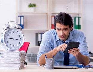Young male businessman employee unhappy with excessive work