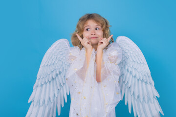 Little cute child at angel costume on isolated background. Kid with angel wings. Isolated studio shot. Funny angel.