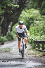 Foto op Plexiglas A cyclist on a racing bike on a mountain road © michelangeloop