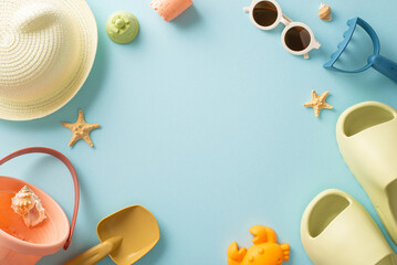 Vacation with children concept. Above view vertical photo of empty space surrounded by child beach toys, panama, flip-flops and sunglasses and shells on blue isolated background