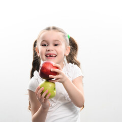 On a white background, the girl holds two green and red apples in her hands