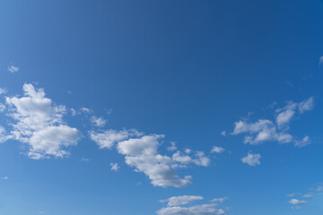 white fluffy clouds standing out against a black background and a blue sky