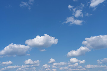 white fluffy clouds standing out against a black background and a blue sky