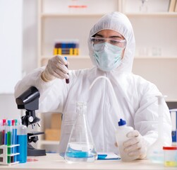 Fototapeta premium Young handsome chemist working in the lab
