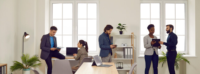 Diverse people working in a modern office. Multiracial company employees meet in a spacious office, work together, and discuss corporate business projects. Banner background