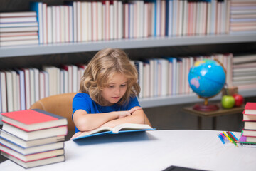 Intellectual child, clever pupil. School boy reading book in library. Kids development, learn to read. Pupil reading books in a book store.