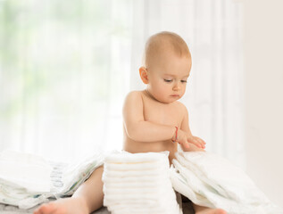 Cute baby playing with new diapers
