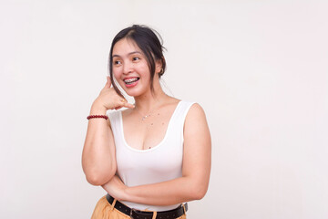 An energetic young Asian woman with braces doing a call me gesture while looking to the left. Isolated on a white background.