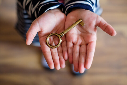 Closeup of an old keyhole with key on a wooden antique door